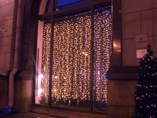 Decorative lighting of store windows using curtain lights.